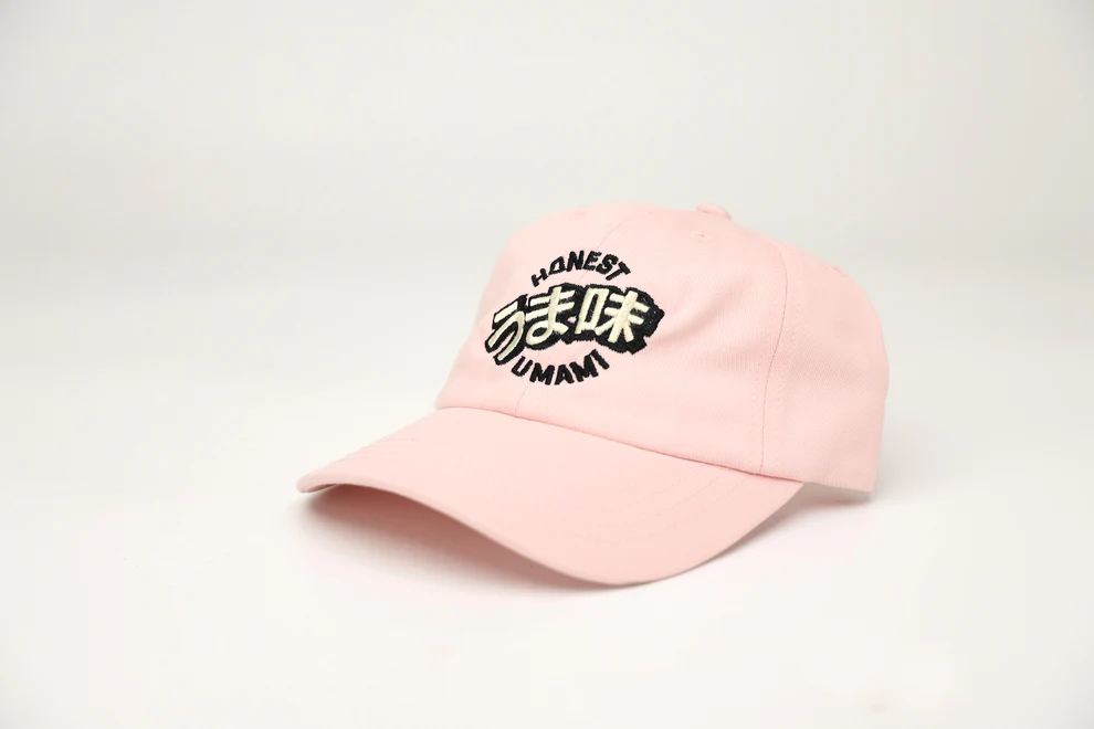 A pink baseball cap with the Honest Umami logo